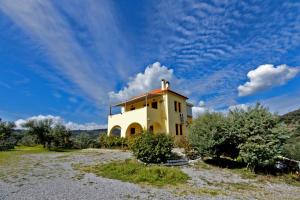 una casa en una colina con un cielo azul en Elaionas Studios, en Gythio