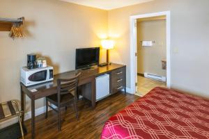 a hotel room with a desk with a microwave and a bed at Econo Lodge Miramichi in Miramichi