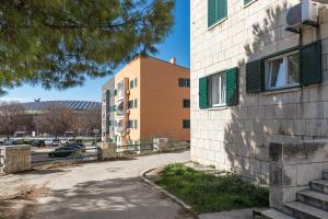 a building with green shuttered windows and a parking lot at Cool Suite in Split