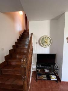 科米利亞斯的住宿－Apartamento Las Martas，楼梯旁墙上的带时钟的楼梯