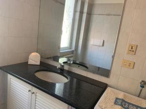 a bathroom with a sink and a mirror at Appartamento Tevere in Finale Ligure +10 photos