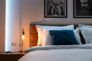 a bedroom with a bed with a blue pillow at Skanderbeg Square Modern App - THE NEST in Tirana