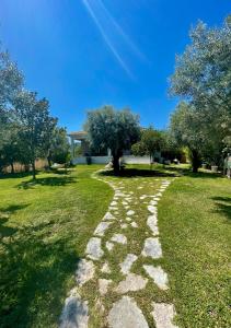 a stone path in a field with trees at Apollon Paian , Luxury Nature Relax in Lefkada Town