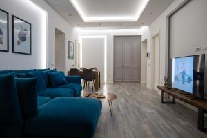 a living room with a blue couch and a television at Skanderbeg Square Modern App - THE NEST in Tirana
