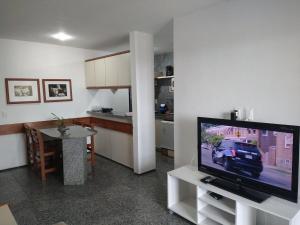 a living room with a television and a kitchen at Iracema Flat 2102 Beira Mar in Fortaleza