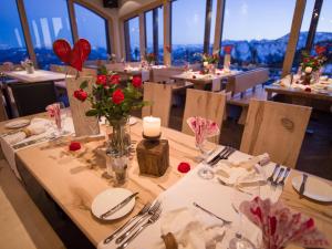 a table with roses in a restaurant with a view at Sonnenalm Kampenwand in Aschau im Chiemgau