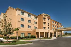 Courtyard by Marriott San Antonio SeaWorld/Lackland في سان انطونيو: مبنى كبير فيه سيارة متوقفة أمامه