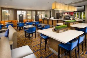 a restaurant with tables and chairs and a kitchen at Courtyard by Marriott San Antonio SeaWorld/Lackland in San Antonio
