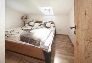 a bedroom with a bed with a black and white comforter at Sonnenalm Kampenwand in Aschau im Chiemgau