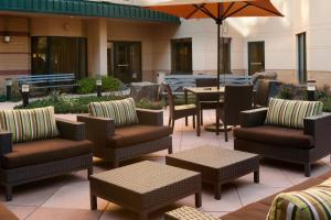 a patio with chairs and tables and an umbrella at Courtyard By Marriott Jersey City Newport in Jersey City