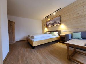 ein Schlafzimmer mit einem Bett und einem Sofa darin in der Unterkunft Landgasthof Wangerstuben in Oberostendorf