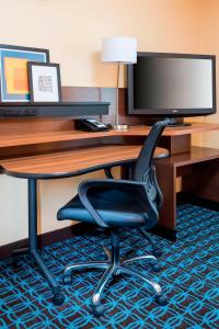 einen Schreibtisch mit einem Computermonitor und einem Stuhl in der Unterkunft Fairfield Inn & Suites Tyler in Tyler