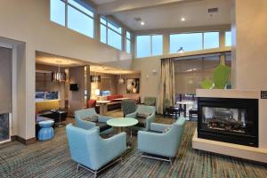 a lobby with blue chairs and a fireplace at Residence Inn by Marriott Houston Northwest/Cypress in Cypress