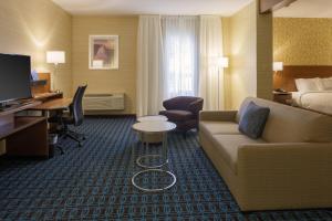 Cette chambre d'hôtel dispose d'un canapé, d'un lit et d'un bureau. dans l'établissement Fairfield Inn & Suites by Marriott Belleville, à Belleville