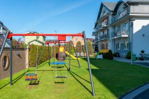 a playground with a swing in a yard at Pensjonat Nautilus in Karwia