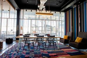 a dining room with a table and chairs and a large window at Aloft Tulsa in Tulsa