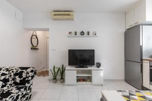 een witte woonkamer met een tv en een bank bij Cool Suite in Split