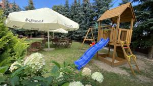 a playground with a slide and an umbrella at Chata Karczowiska in Karczowiska