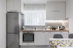 a kitchen with white cabinets and a sink and a table at Cool Suite in Split