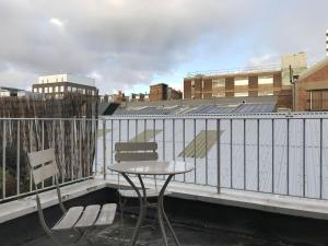 uma mesa e duas cadeiras numa varanda em 25 Ongar Road by Viridian Apartments em Londres