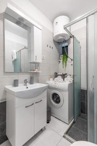een badkamer met een wastafel en een wasmachine bij Cool Suite in Split