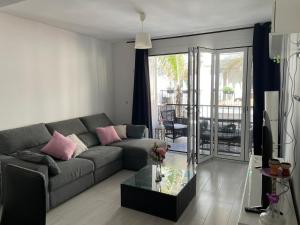 een woonkamer met een bank en een glazen tafel bij Apartamento playa Fuengirola centro paseo marítimo in Fuengirola