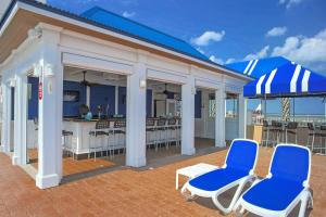 un patio con sillas, una mesa y un bar en SpringHill Suites by Marriott Virginia Beach Oceanfront en Virginia Beach