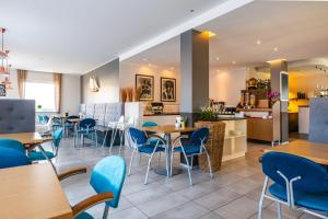 a restaurant with tables and chairs and a kitchen at Pensjonat Nautilus in Karwia