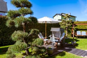 a patio with two chairs and a table with an umbrella at Pensjonat Nautilus in Karwia