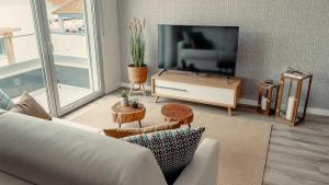 un soggiorno con divano e TV di Shellter Apartments by the sea a Vieira de Leiria
