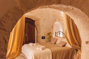 1 dormitorio con 2 camas en una pared de piedra en Masseria Montanaro, en Cisternino