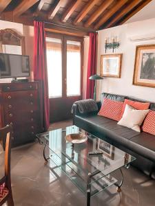 - un salon avec un canapé et une table en verre dans l'établissement Apartamentos en pleno centro, Aljibe Rodrigo del Campo 2B, à Grenade