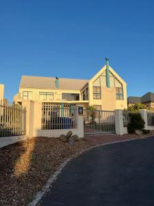 a house with a fence in front of it at Villa Paulina Family suite in Langebaan