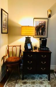 a lamp sitting on a dresser next to a chair at Clevedale Historic Inn and Gardens in Spartanburg