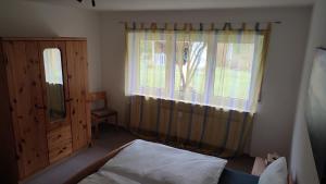 a bedroom with a bed and a window with curtains at Leimbach in Bad Brückenau