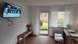 a living room with a tv on the wall and a window at Leimbach in Bad Brückenau