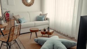 un soggiorno con divano bianco e tavolo di Shellter Apartments by the sea a Vieira de Leiria