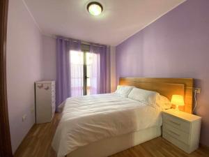 Un dormitorio con una gran cama blanca y una ventana en La Magdalena acogedor apartamento en Villaviciosa en Villaviciosa
