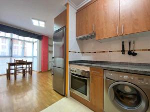 a kitchen with a washer and dryer and a table at La Magdalena, piso en Villaviciosa VUT-3402-AS in Villaviciosa