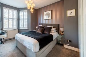 ロンドンにあるPass the Keys Stunning House in Walthamstowのベッドルーム1室(大型ベッド1台、シャンデリア付)