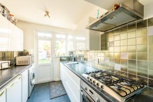 a kitchen with a stove top oven in a kitchen at Pass the Keys Stunning House in Walthamstow in London