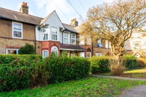 a large brick house with a tree in the yard at Pass the Keys Stunning House in Walthamstow in London