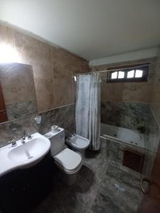 y baño con aseo y lavamanos. en Casa Solares en Villa Carlos Paz