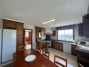 a kitchen with a wooden table and a dining room at ATALAYA RIAS BAIXAS in Pontevedra