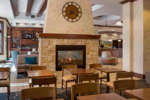 a restaurant with a fireplace and tables and chairs at SpringHill Suites Napa Valley in Napa