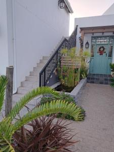 a staircase leading to a house with a blue door at Cape Dutch Flair in Durbanville