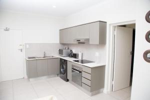 cocina con fregadero y lavadora en Secured and Fully equipped apartment- E en Lombardy East