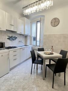 a kitchen with a table and chairs and a kitchen with white cabinets at Casa Vacanze Armanda in Lerici