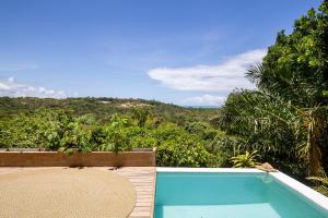 a swimming pool with a view of the jungle at Alma Ninho Trancoso in Trancoso