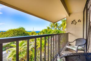 Un balcón con una silla y vistas al océano. en Kalanikai 321 en Kailua-Kona